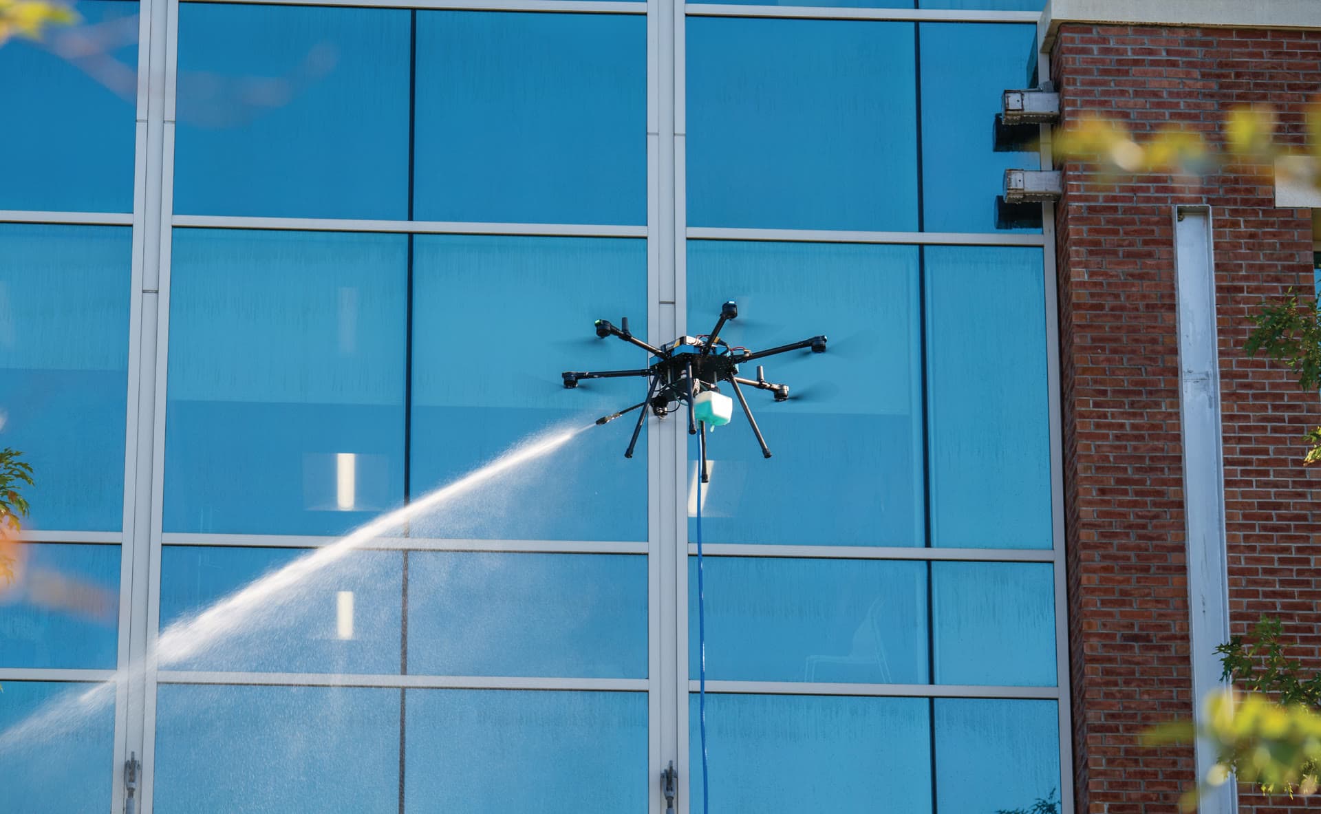 Drone cleaning glass facade of a commercial building