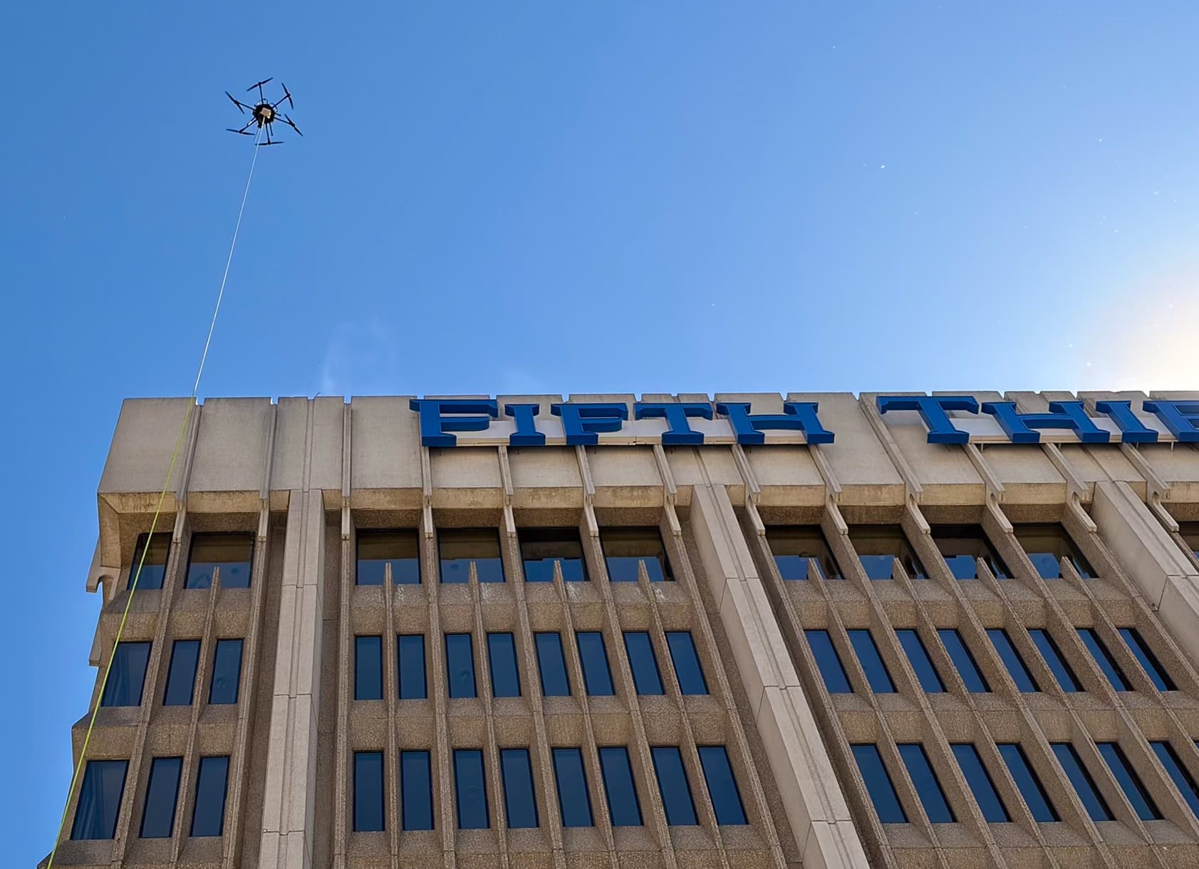 Clear Edge tethered drone cleaning the upper floors of the Fifth Third Bank building in downtown Grand Rapids
